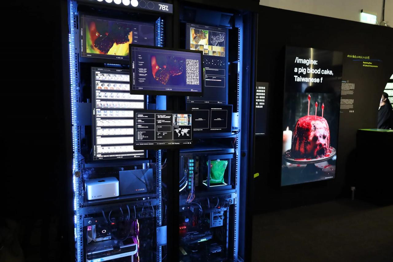 展示風景。複数のモニターや配線、パソコンで構成されたマシンと、AI生成された不気味なビジュアルの画像が映し出されたモニターの展示。