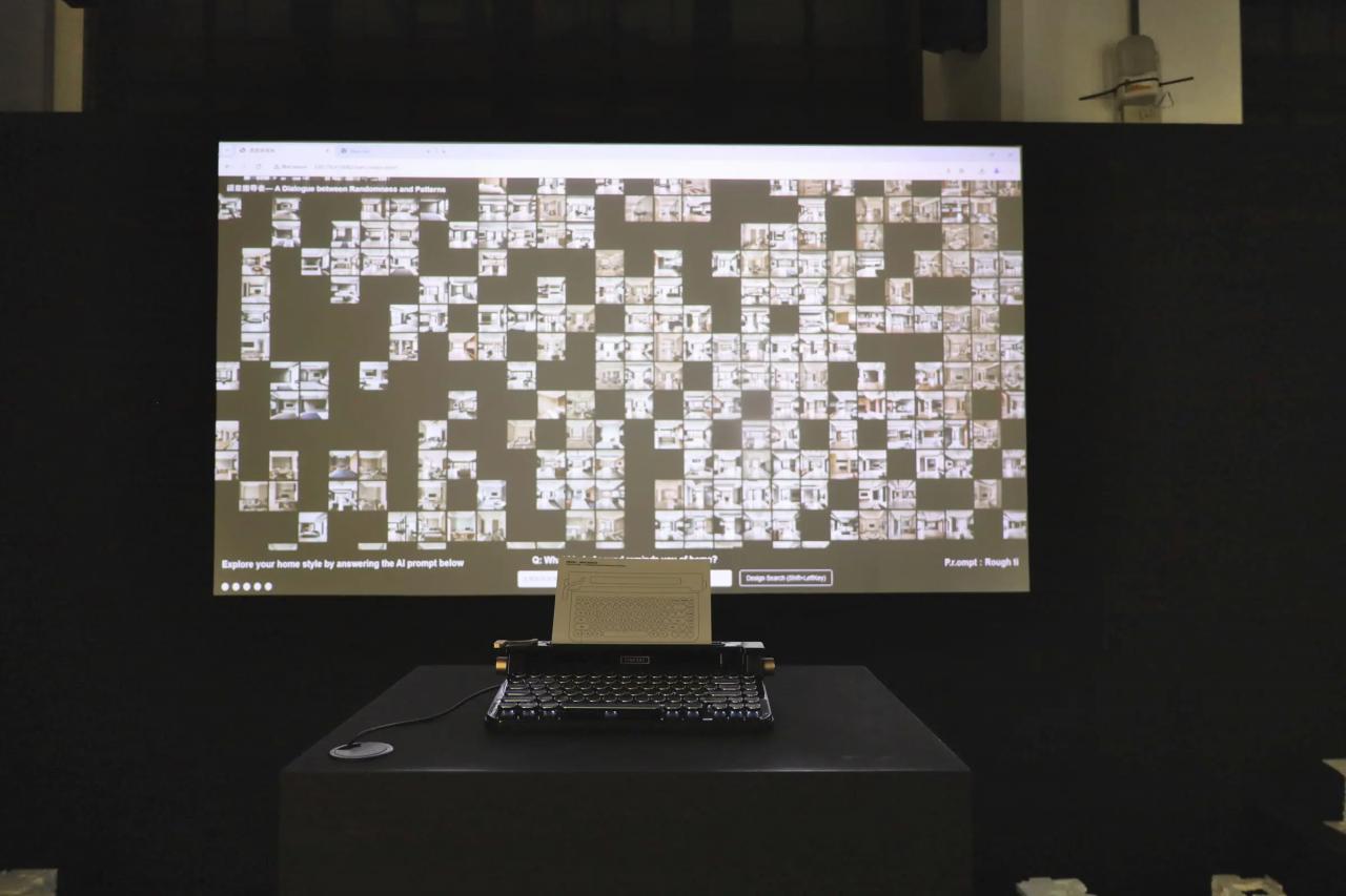 展示風景。タイプライターの前に大きなモニターが設置され、無数の内装のパターンが映し出されている