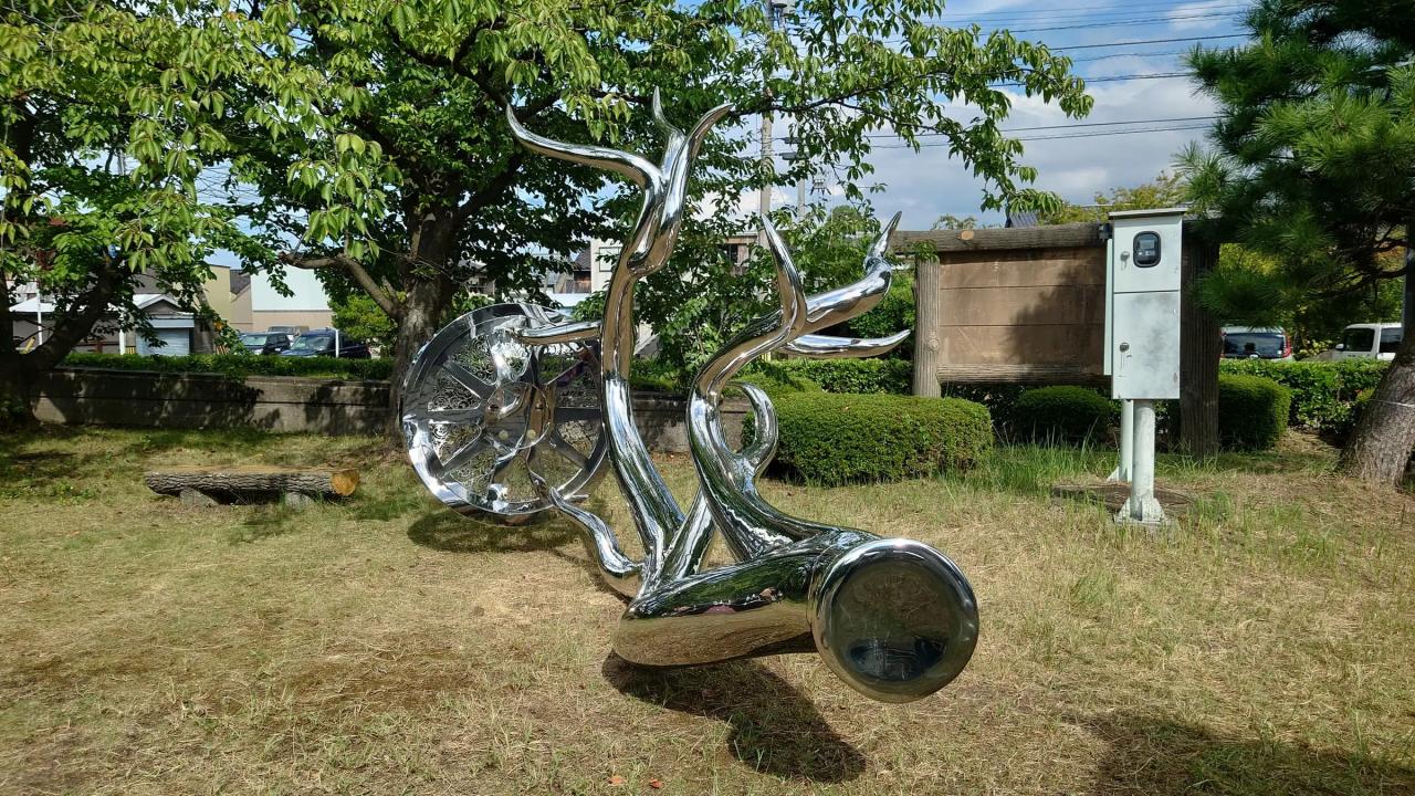 金属製の巨大な鹿の角に車輪がついた造形作品