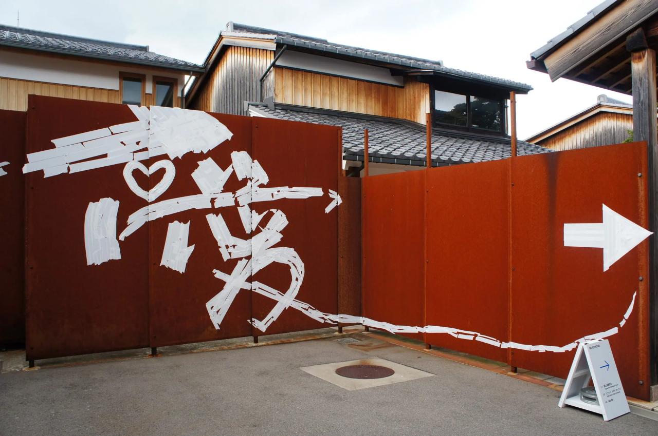 店外の壁にマスキングテープで書かれた「愛」の漢字