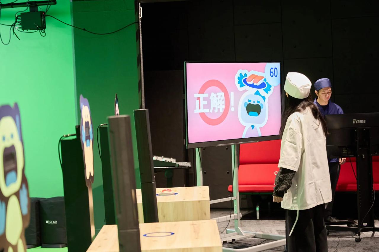 ゲームで実際に遊ぶ様子。寿司を運んだあと、モニターに正解の文字が表示されている