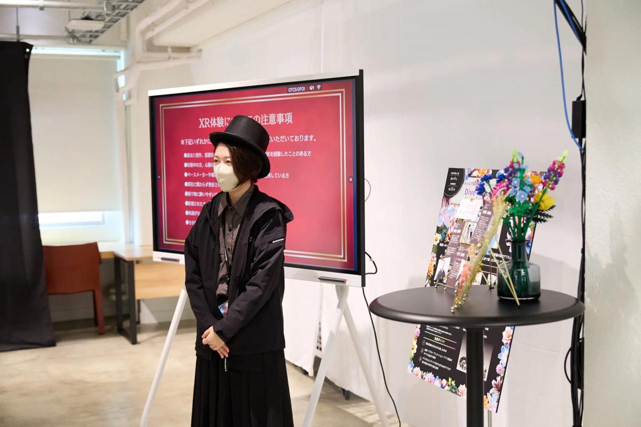 シルクハットを被った丹青社社員がゲームの解説を行う様子